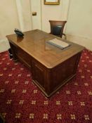 A traditional mahogany executive desk featuring panelled sides and moulded details. The