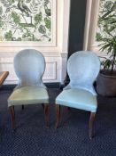 A pair of contemporary dining chairs upholstered in a velvet face fabric with a pattern back wrap