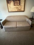 A two-seater sofa bed with a neutral, light-coloured fabric upholstery A streamlined, modern