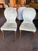 A pair of contemporary dining chairs upholstered in a velvet face fabric with a pattern back wrap