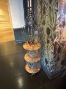 A tall, decorative shelving unit designed in the style of a large, open birdcage. It features a dark