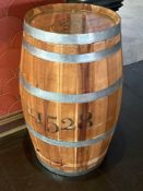 Oak wooden barrel repurposed as a side table polished, natural wood finish with metal bands