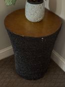 Side table a dark, textured, conical-shaped pedestal or stand itself has a rough, bark-like