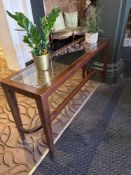 Console table with a glass top the table is crafted from dark wood and features a clear glass