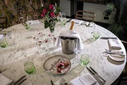 A Large circular dining table the marble effect melamine top raised on a wooden pedestal 180 x