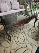 2 x Mahogany low level coffee table tempered black glass top raised over a shaped apron standing