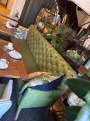 A chesterfield style sofa in distressed green leather the back rest tufted and raised on splayed