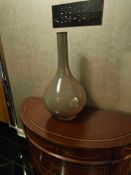 A tall, sculptural ceramic vase by Asiatides, Paris, featuring a bulbous base, narrow neck, and