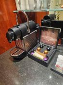 Nespresso Pod machine A compact capsule-based espresso machine in matte black with ribbed