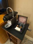 Nespresso Pod machine A compact capsule-based espresso machine in matte black with ribbed