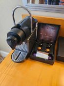 Nespresso Pod machine A compact capsule-based espresso machine in matte black with ribbed