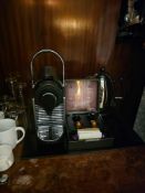 Nespresso Pod machine A compact capsule-based espresso machine in matte black with ribbed