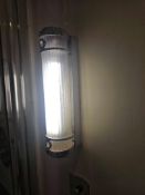 A pair of compact, wall-mounted light fitting with a ribbed cylindrical plastic diffuser, framed