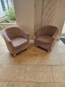 A pair of modern upholstered tub chair with a rounded back and curved arms textured fabric in a