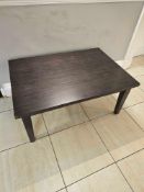 Rectangular coffee table, approx. 100 × 70 cm, with dark wood veneer top and four straight legs. [