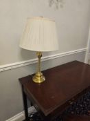 Three-arm table lamp in polished brass, featuring a circular base and slender stem supporting