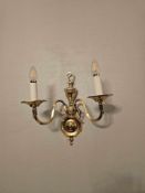 A set of 4 x Twin-arm wall light in polished brass. Scrolling arms with candle-style bulb holders,