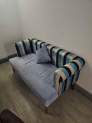 Compact upholstered bench or settee featuring a bold multicoloured striped backrest and arms in