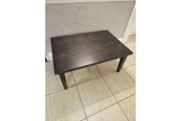 Rectangular coffee table, approx. 100 × 70 cm, with dark wood veneer top and four straight legs. [