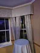 A set of window treatment drape curtains set with poles and valance span approximately 5m wide x