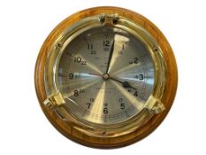 BELL CLOCK CO BRASS SHIPS PORT HOLE WALL CLOCK WITH ROUND WOODEN FRAME