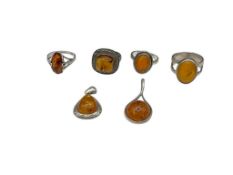 SIX STERLING SILVER AMBER RINGS AND PENDANTS