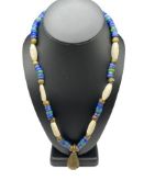 VINTAGE NECKLACE FEATURING CARVED BONE AS WELL AS BLUE AND GREEN ART GLASS BEADS WITH BELL PENDANT