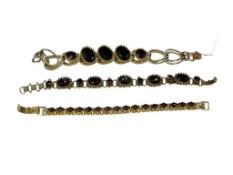 THREE GARNET COLORED STONE GOLD TONE COSTUME BRACELETS