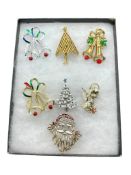 SEVEN ASSORTED CHRISTMAS HOLIDAY BROOCHES INCLUDING SANTA CLAUS, CHRISTMAS TREES, AND SOME SIGNED