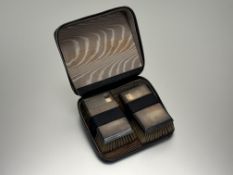 A pair of Birmingham silver-backed traveling hair brushes with original black pebbled leather