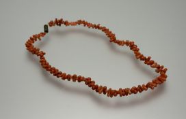 A 1920s vintage pink coral bead and thong style necklace with barrel clasp: l. x 21cm