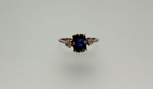A yellow metal mounted ring set cushion cut sapphire approximately 1ct flanked by a brilliant cut