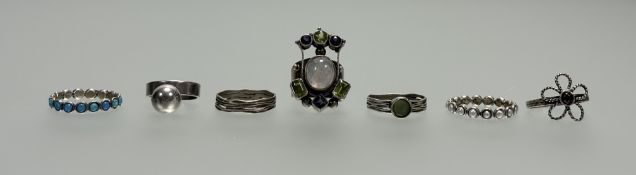 A collection of seven white metal and silver rings to include a multi gem peridot, moonstone and