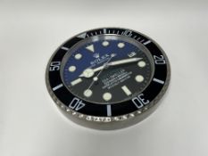 A Dealer Display circular wall clock, styled after a Rolex 'Deepsea Sea-Dweller', with black to blue