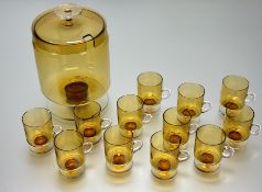 A collection of twelve retro amber glass cups raised on circular base (h-10cm) together with an