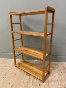 A modern pine open bookcase, with four fixed shelves supported by two ladder style sides, on