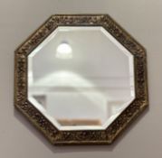 A hexagon shaped hall mirror with embossed tulip and foliate border with bevelled glass panel. (