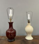 A Chinese porcelain table lamp of bulbous form, with sang de boeuf glaze and mounted on a wooden