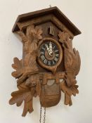 A 20th century West German treen cuckoo clock, decorated with hunting scenes and carved stag head
