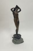 A cast bronze figure of Venus, the figure raised on a clam shell and shaped metal rock support (h.