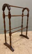 An Edwardian oak five-bar towel rail, with turned shaped supports and carved leaf detail to sides