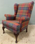 A contemporary oak-framed wingback armchair, upholstered in a red, green and teal tartan check