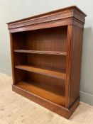 A reproduction mahogany bookcase, with moulded top and carved cornice over two adjustable shelves,
