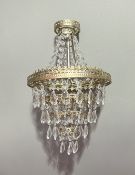 A five-tiered hanging chandelier in the French Empire style, chrome-framed with clear acrylic drops,