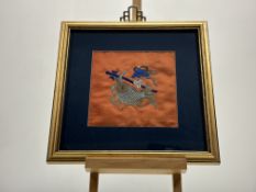 A pair of framed Chinese silk embrodiery panels, one depicting a koi fish on orange ground the other