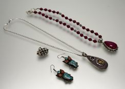 An eastern white metal necklace with a red bead and ball-mounted chain with pear-shaped pink stone
