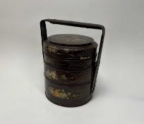 A Chinese lacquered three-tiered storage basket of cylindrical form, the upper compartment with