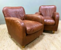 A pair of contemporary brown leather Havana armchairs, by Habitat, with shaped backs and arms and
