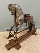 A mid-century pine-framed rocking horse, with real horse hair mane and tail, leather saddle and
