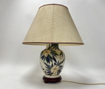 A large ceramic table lamp with polychrome parrots and floral detail to body, raised on a wooden